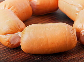 Meat sausages on an old wooden background.