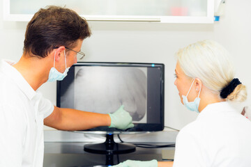 Obraz premium Dentist And Assistant Looking At Dental X-ray