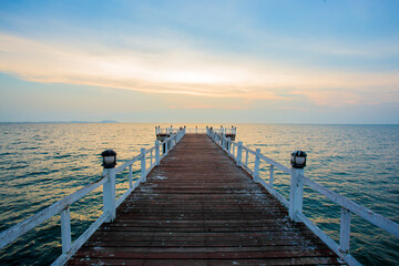 Fototapeta premium The wooden bridge on sea at sunset, Thailand.