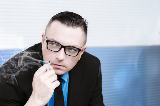 man, manager or businessman in a suit smoking a cigarette