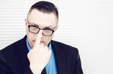 man or businessman in a suit holding eyeglasses closeup