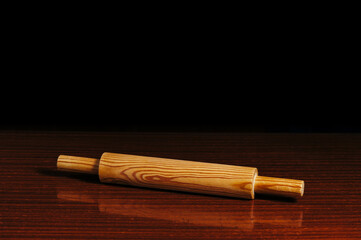 Beautiful wooden rolling pin on a wooden brown table. Subject photography. Concept.