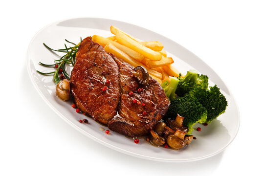 Grilled beefsteak with french fries and broccoli on white background