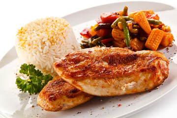 Roast chicken filet with rice and vegetables on white background