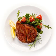 Grilled beefsteak with vegetables on white background