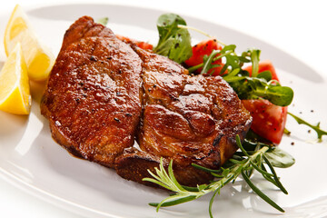 Grilled beefsteak with vegetables on white background