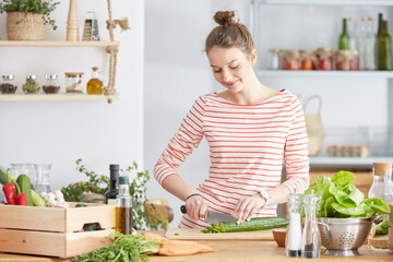 Woman cutting a cucumber