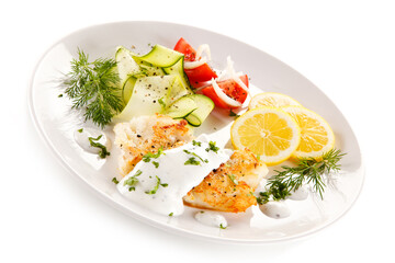 Fried cod and vegetables on white background