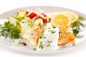 Fried cod and vegetables on white background