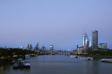 skyscrapers in london city with st paul's cathedral at night seen over thames river