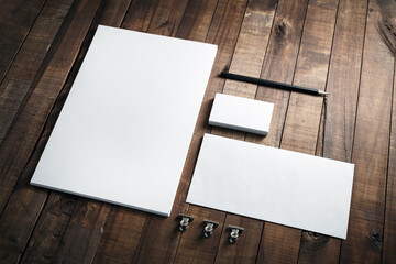 Photo of blank stationery set on wood background. Envelope, business cards, pencil, and A4 paper....