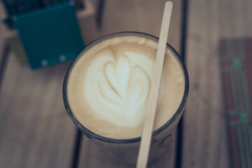 Latte art in glass. Coffee espresso on wooden table