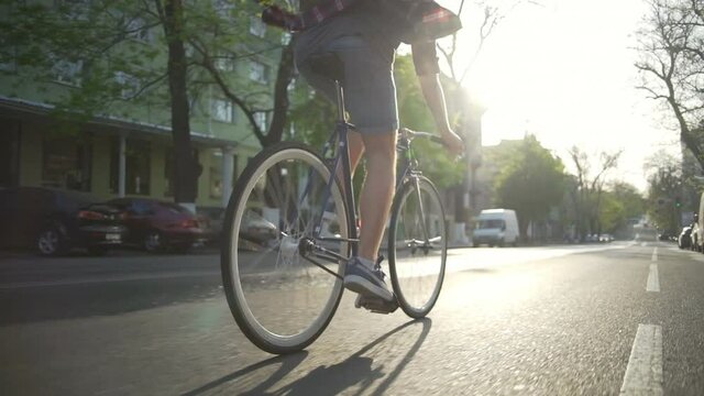 Man in checkered shirt riding his bike on the street slow motion