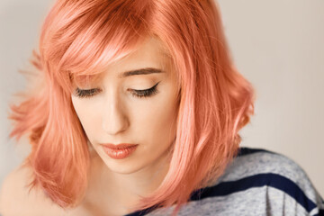 Beautiful young woman with dyed hair on color background, closeup