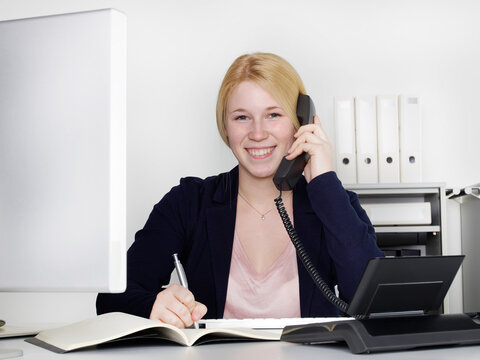Female office assistant has a call at the office