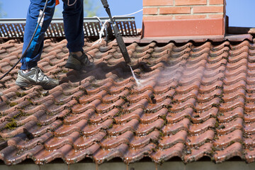 Washing the roof with a high pressure water washer. - 157450384