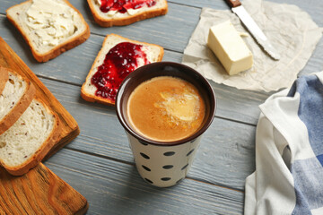 Composition with tasty butter coffee and toasts on wooden table