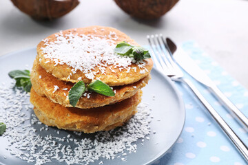 Plate with tasty homemade coconut pancakes and mint on table