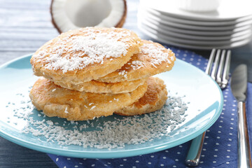Plate with tasty homemade coconut pancakes on table