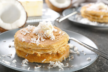 Plate with tasty homemade coconut pancakes on table
