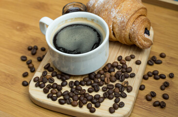 Delicious fresh croissants with fruit jam and coffee on wooden