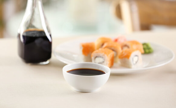 Bowl with tasty soy sauce on table