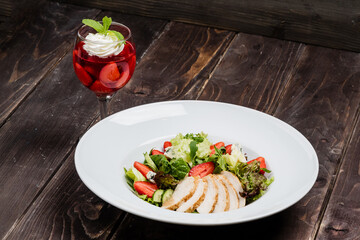 Spring salad with meat and strawberry with strawberry dessert, on a wooden table, country style
