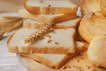 Delicious sliced bread on wooden cutting board, closeup