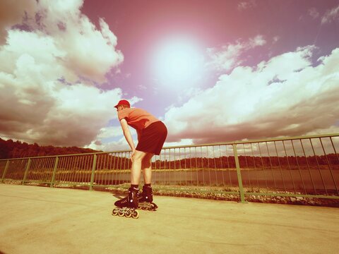 Vintage tone filter effect color style. Sportsman  with inline skates ride in summer park