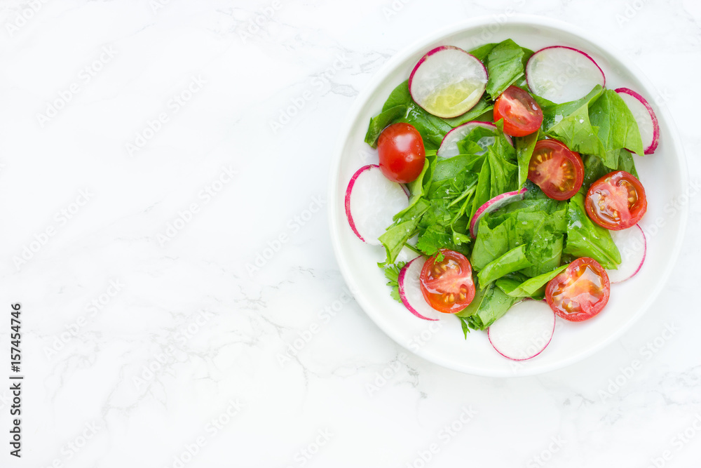 Wall mural Mixed green salad with fresh spinach, radish and cherry tomatoes