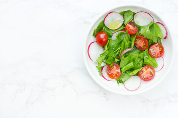 Mixed green salad with fresh spinach, radish and cherry tomatoes
