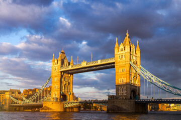 Fototapeta na wymiar Tower Bridge in London, the UK. Sunset with beautiful clouds. Drawbridge opening. One of English symbols