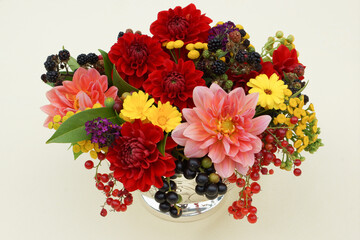 gartenblumen mit dahlien in silberschale auf holztisch vor steingarten