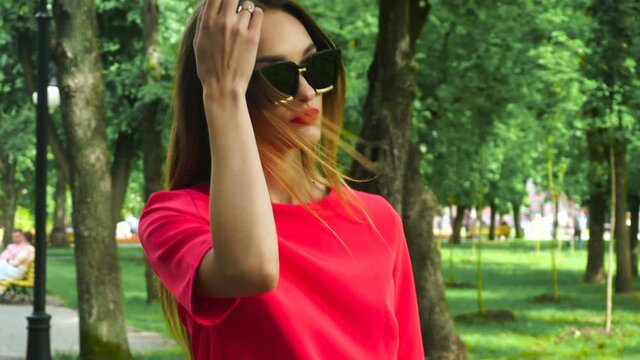 Glamour young blode lady in red suit and sunglasses