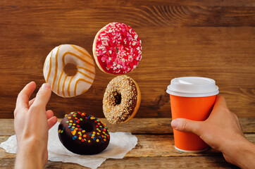 Men's hand with flying donuts and coffee