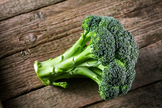 Fresh broccoli on a dark wooden background, top view