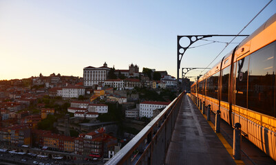 Ponte Dom Luís I during sunset with yellow metro trams - Porto, Portugal