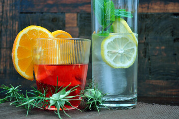 Glasses with refreshing drinks with fruits and herbs on an old wooden background