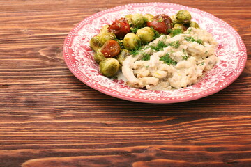 Tasty chicken meat under creamy sauce with brussels sprouts garn