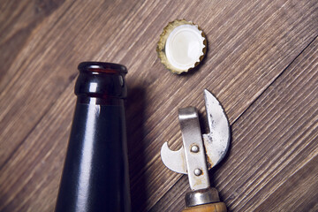 A bottle of beer, a lid and a bottle opener
