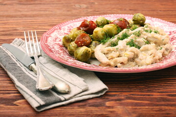 Tasty chicken meat under creamy sauce with brussels sprouts garn