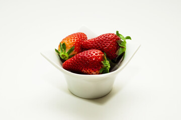Truskawki w biały pojemnik na białe izolowane tło