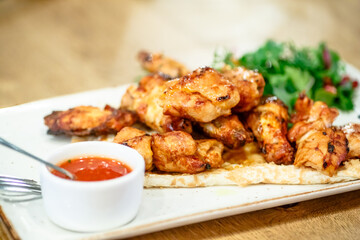 Chicken kebab with tomato sauce, herbs and pomegranate seeds.