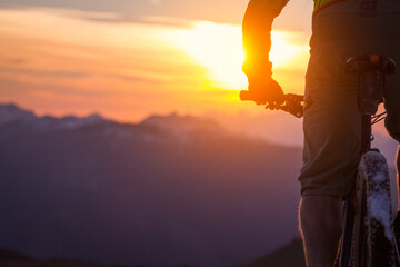 Fototapeta na wymiar Silhouette of a male mountainbiker at sunset in the mountains