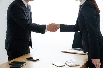 商談をするビジネスウーマンとビジネスマン、成約、握手