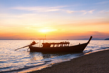 Silhouette of a traditional long-tail boat, beach, sunset