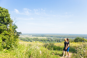 Couple enjoying a walk through grass land and looking far away