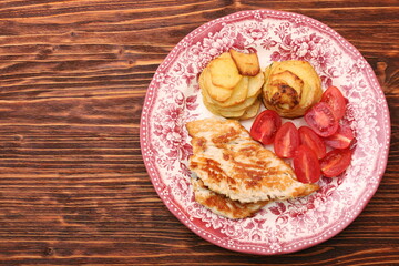 Fried turkey fillets, roasted potatoes and cherry tomato