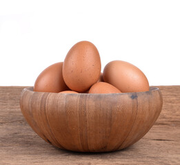 eggs in a wooden bowl on wooden floor