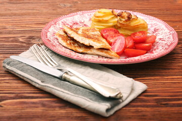 Fried turkey fillets, roasted potatoes and cherry tomato